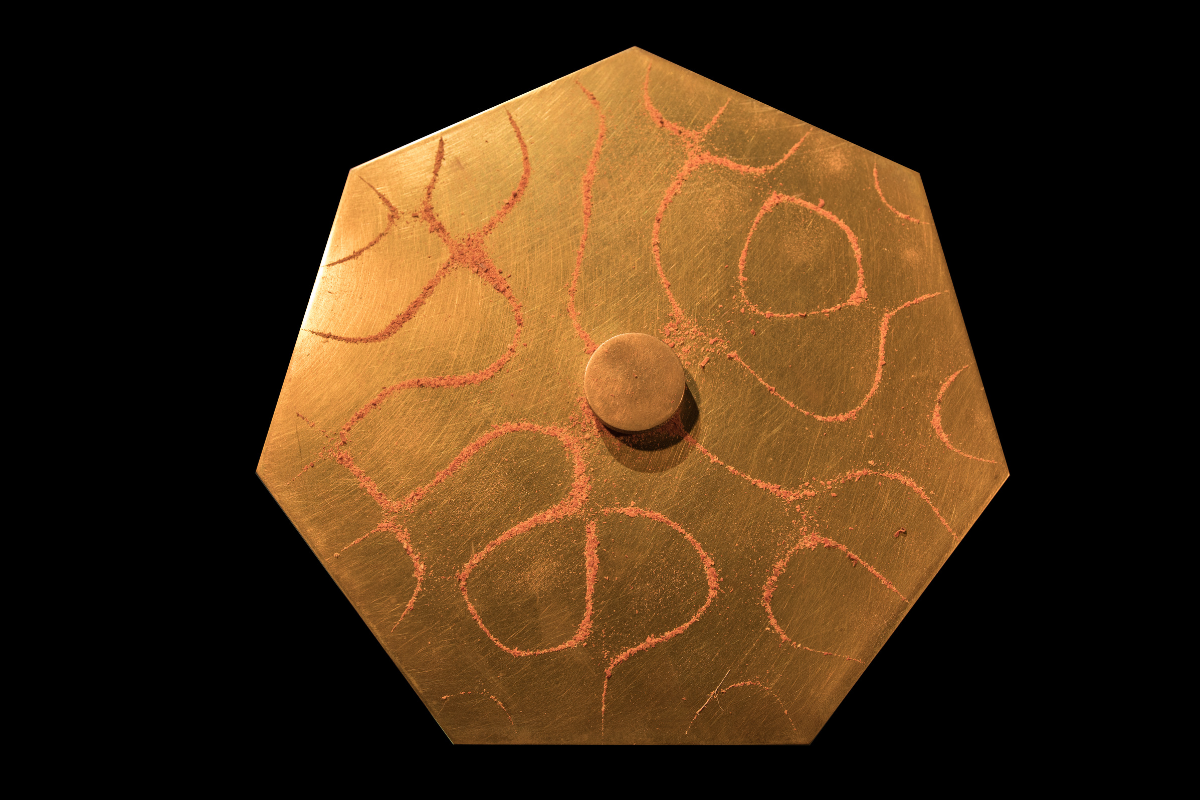 Imagen de un plato metalico de cobre con particulas generando figuras de Chladni.